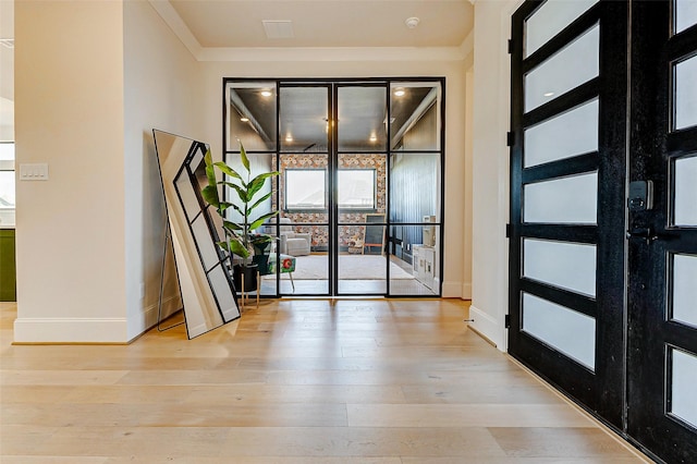 7606 Redwoods Forest Dr, Katy, TX 77493 - doorway with light wood-style floors, baseboards, and ornamental molding