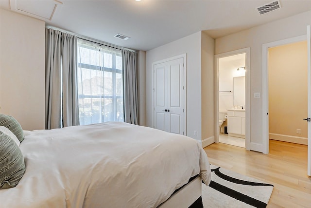 7606 Redwoods Forest Dr, Katy, TX 77493 - bedroom with light wood-style floors, visible vents, baseboards, and connected bathroom