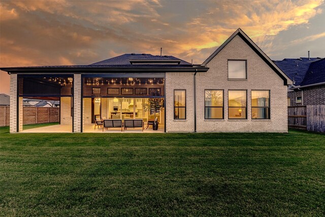 7606 Redwoods Forest Dr, Katy, TX 77493 - back of property at dusk with an outdoor living space, a fenced backyard, a lawn, a patio area, and brick siding