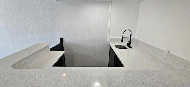 47 W Dansby Dr, Galveston, TX 77551 - kitchen with a textured wall, light stone countertops, and a sink
