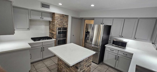 47 W Dansby Dr, Galveston, TX 77551 - kitchen with gray cabinets, appliances with stainless steel finishes, light tile patterned flooring, and visible vents