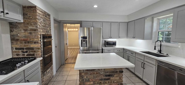 47 W Dansby Dr, Galveston, TX 77551 - kitchen with light tile patterned floors, gray cabinets, appliances with stainless steel finishes, a sink, and light countertops