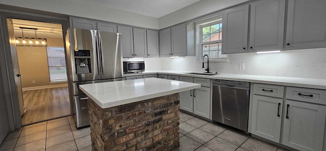 47 W Dansby Dr, Galveston, TX 77551 - kitchen with light tile patterned flooring, gray cabinetry, a sink, and appliances with stainless steel finishes