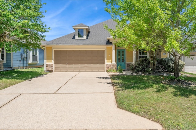 view of front of house with concrete driveway, stone siding, a front yard, a garage, and a shingled roof
