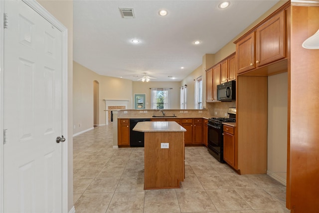 kitchen with visible vents, a sink, ceiling fan, a peninsula, and black appliances