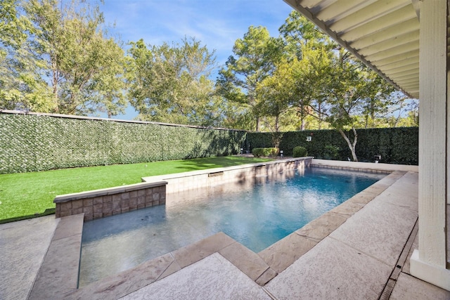 view of swimming pool with a fenced in pool, a patio, a fenced backyard, and a lawn