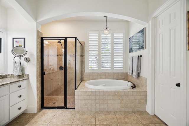 full bath with vanity, tile patterned flooring, a stall shower, and a garden tub