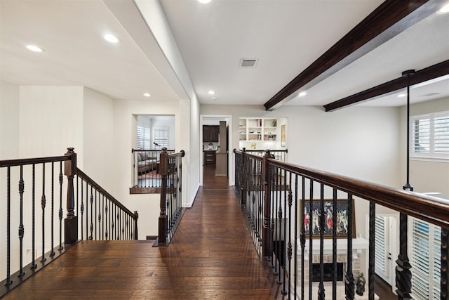hallway with wood finished floors, beamed ceiling, an upstairs landing, and recessed lighting