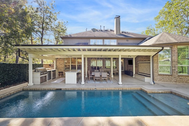 back of property featuring exterior kitchen, a fenced in pool, a chimney, a patio area, and brick siding