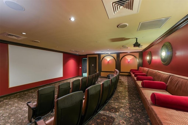cinema room with carpet, visible vents, baseboards, and ornamental molding