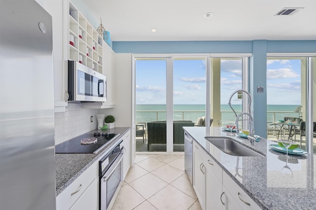 kitchen featuring a water view, visible vents, stainless steel appliances, and a sink
