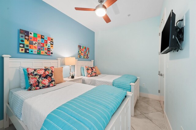 bedroom with ceiling fan, baseboards, and light tile patterned floors