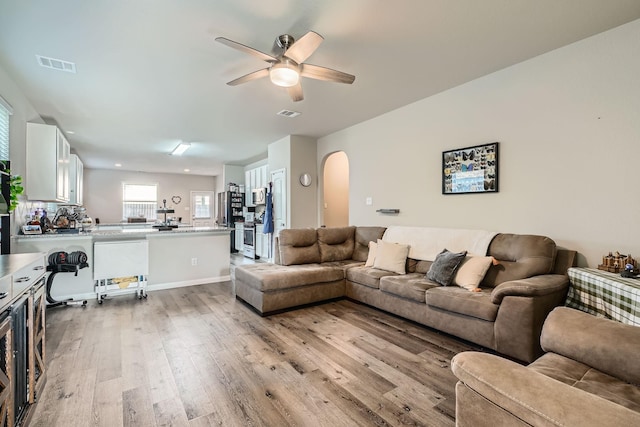 25639 Brooklyn Ln, Porter, TX 77365 - living area with arched walkways, light wood finished floors, a ceiling fan, and visible vents
