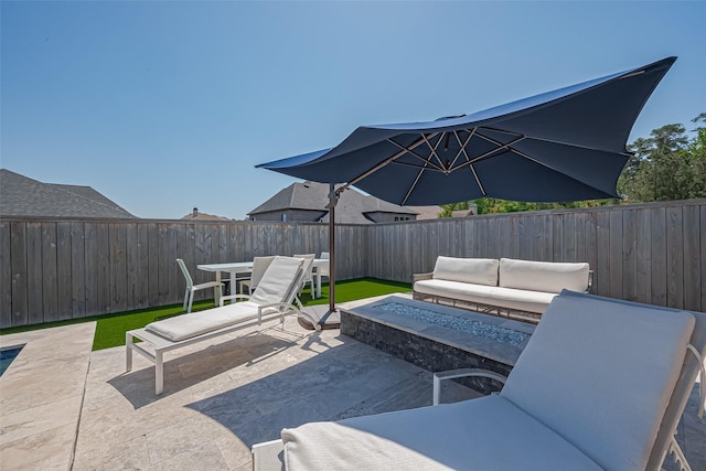 1011 Oak Briar Ln, Conroe, TX 77384 - view of patio with a fenced backyard and an outdoor living space with a fire pit