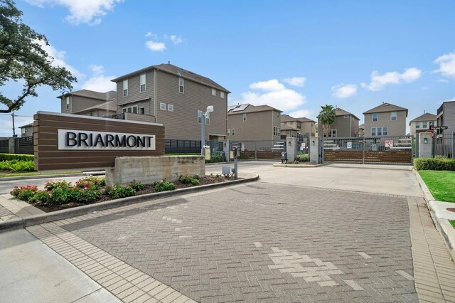 view of street with a gated entry, a residential view, a gate, and curbs