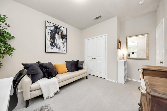 living room featuring baseboards, light carpet, and visible vents