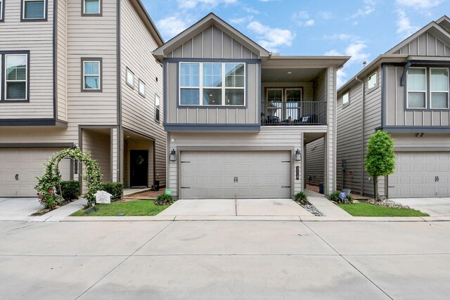 view of front of house with board and batten siding, an attached garage, concrete driveway, and a balcony