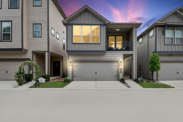 townhome / multi-family property featuring a garage, board and batten siding, a balcony, and concrete driveway
