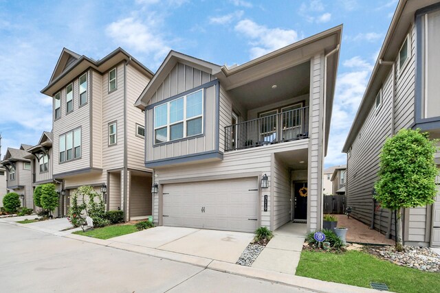multi unit property featuring a garage, board and batten siding, driveway, and a balcony