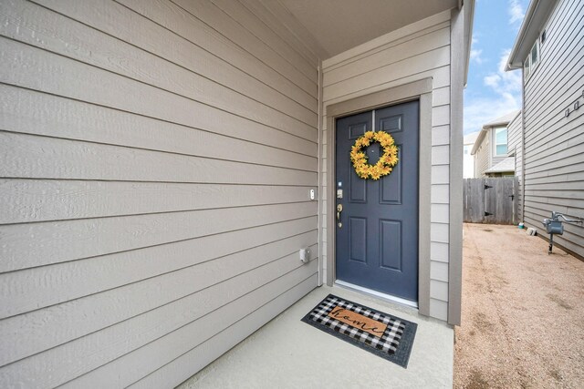 doorway to property featuring fence