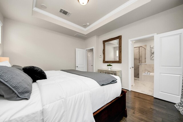 bedroom featuring crown molding, a raised ceiling, ensuite bathroom, visible vents, and dark wood-style floors