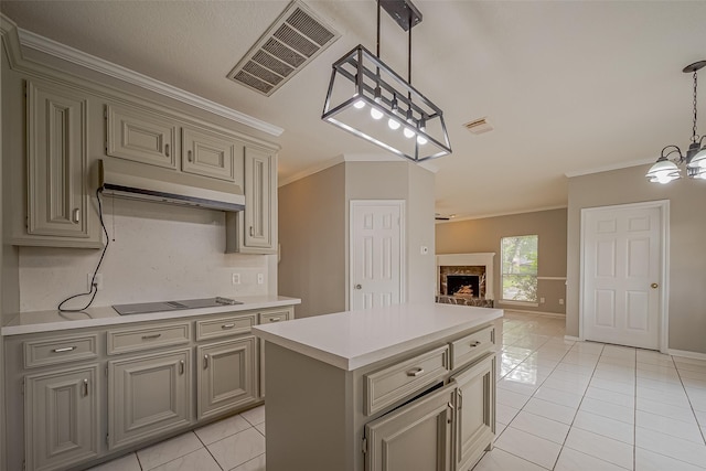 215 Wood Circle Ln, Houston, TX 77015 - kitchen with under cabinet range hood, ornamental molding, black electric stovetop, light tile patterned floors, and gray cabinetry