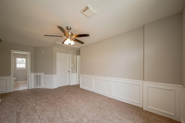 215 Wood Circle Ln, Houston, TX 77015 - spare room featuring wainscoting, a decorative wall, a ceiling fan, carpet, and a textured ceiling
