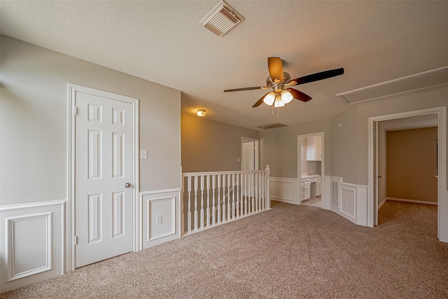215 Wood Circle Ln, Houston, TX 77015 - carpeted spare room featuring attic access, wainscoting, a ceiling fan, a decorative wall, and a textured ceiling