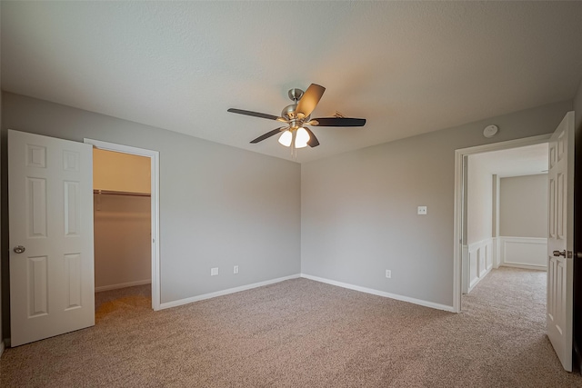 215 Wood Circle Ln, Houston, TX 77015 - unfurnished bedroom with light carpet, a walk in closet, a ceiling fan, a closet, and baseboards