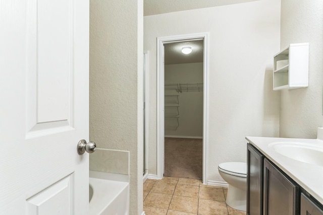 315 Prato Brezza, San Antonio, TX 78253 - full bathroom featuring toilet, a bath, vanity, a walk in closet, and a textured wall