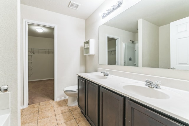 315 Prato Brezza, San Antonio, TX 78253 - bathroom featuring a walk in closet, double vanity, toilet, a shower, and tile patterned floors