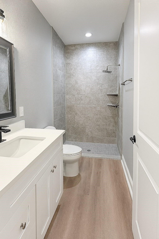 25759 Hickory Ln, Splendora, TX 77372 - bathroom with wood finished floors, a tile shower, vanity, and recessed lighting