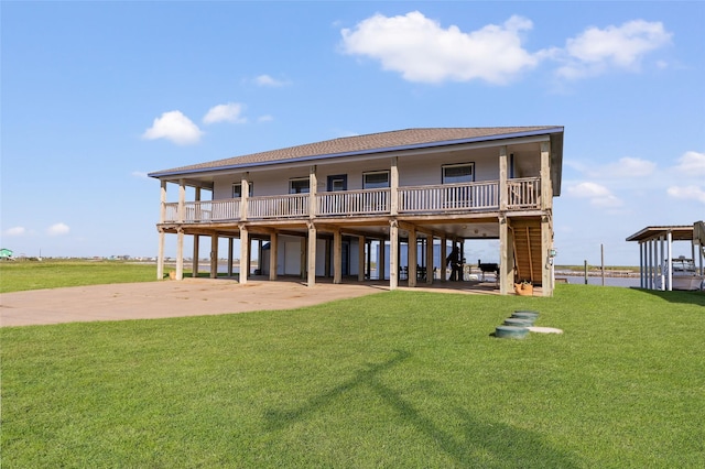 back of house featuring a carport, driveway, a yard, and a shingled roof