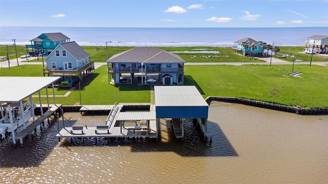 view of dock with a water view and a lawn