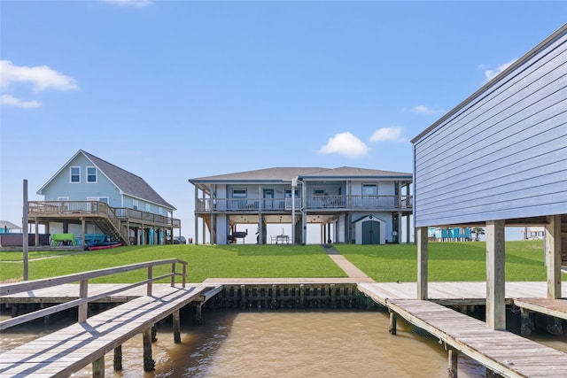 view of dock with a water view and a lawn