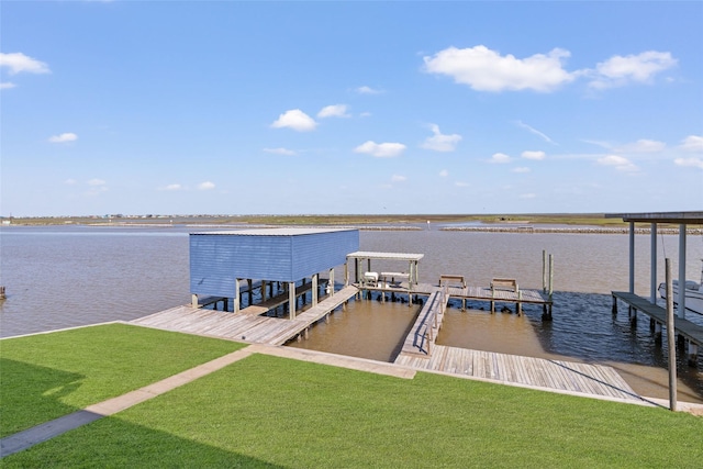 view of dock with a lawn and a water view