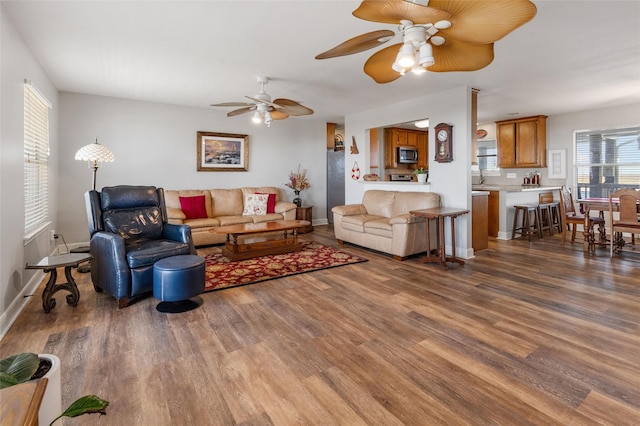living area with wood finished floors, ceiling fan, and baseboards