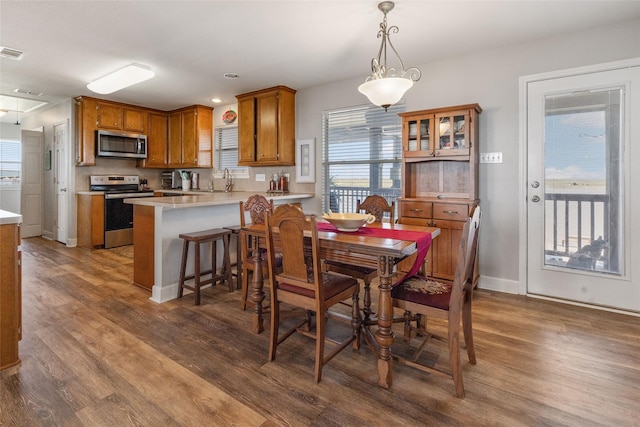 dining room featuring wood finished floors, baseboards, and visible vents