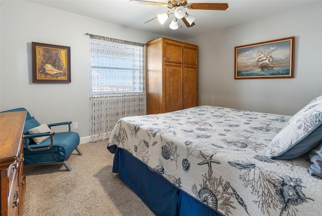 bedroom featuring light carpet, baseboards, and a ceiling fan