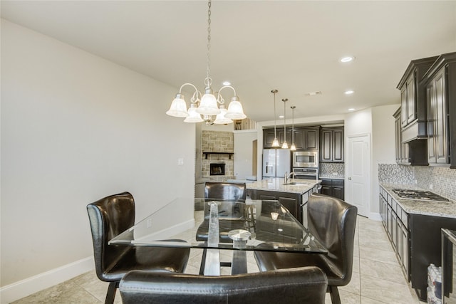 19810 Quarry Stone Ln, Richmond, TX 77407 - dining room featuring light tile patterned floors, baseboards, an inviting chandelier, a fireplace, and recessed lighting