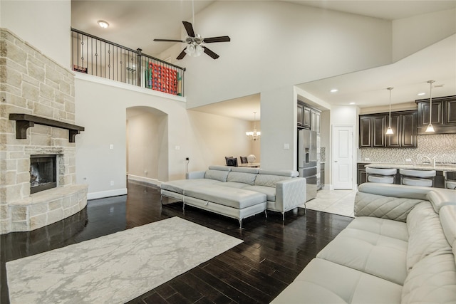 19810 Quarry Stone Ln, Richmond, TX 77407 - living room with high vaulted ceiling, arched walkways, wood finished floors, and ceiling fan with notable chandelier