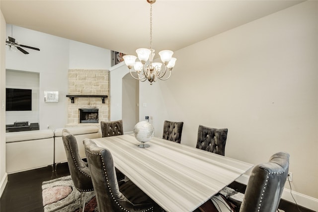 19810 Quarry Stone Ln, Richmond, TX 77407 - dining space with a fireplace, dark wood-style flooring, baseboards, and ceiling fan with notable chandelier