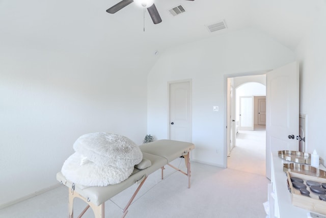interior space featuring ceiling fan, visible vents, light carpet, and vaulted ceiling