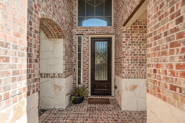 property entrance featuring brick siding