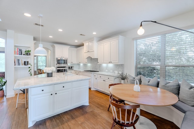 kitchen with visible vents, tasteful backsplash, white cabinets, and stainless steel appliances