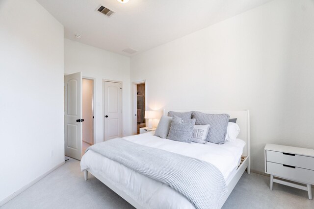 carpeted bedroom featuring baseboards and visible vents