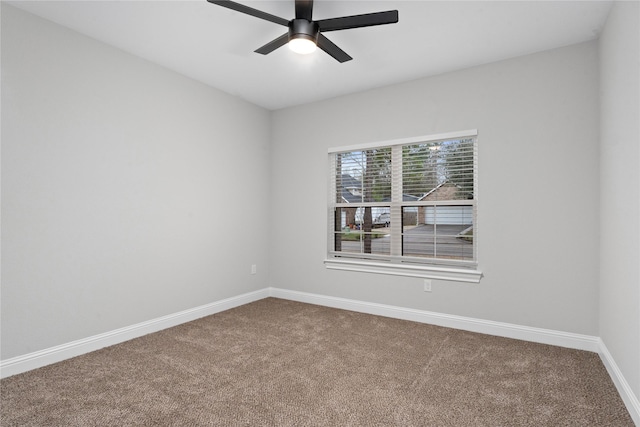 carpeted spare room featuring ceiling fan and baseboards