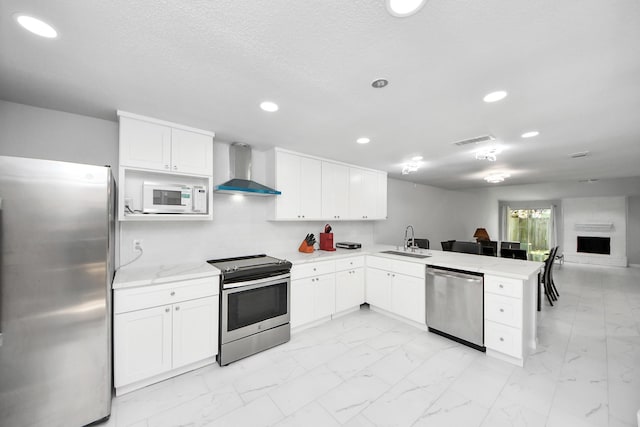 6430 Grandvale Dr, Houston, TX 77072 - kitchen featuring a peninsula, wall chimney range hood, visible vents, a sink, and stainless steel appliances