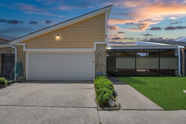 6430 Grandvale Dr, Houston, TX 77072 - garage at dusk featuring fence, a lawn, and concrete driveway