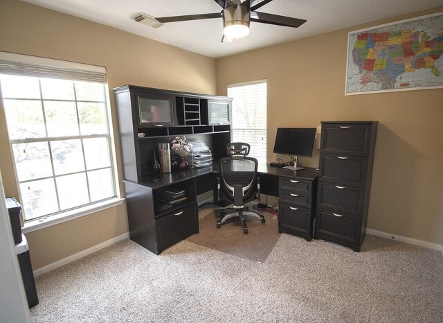office space with ceiling fan, plenty of natural light, light colored carpet, and baseboards